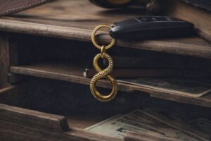 En bilnyckel med en guldnyckelring formad som en åtta på en rustik trähylla.