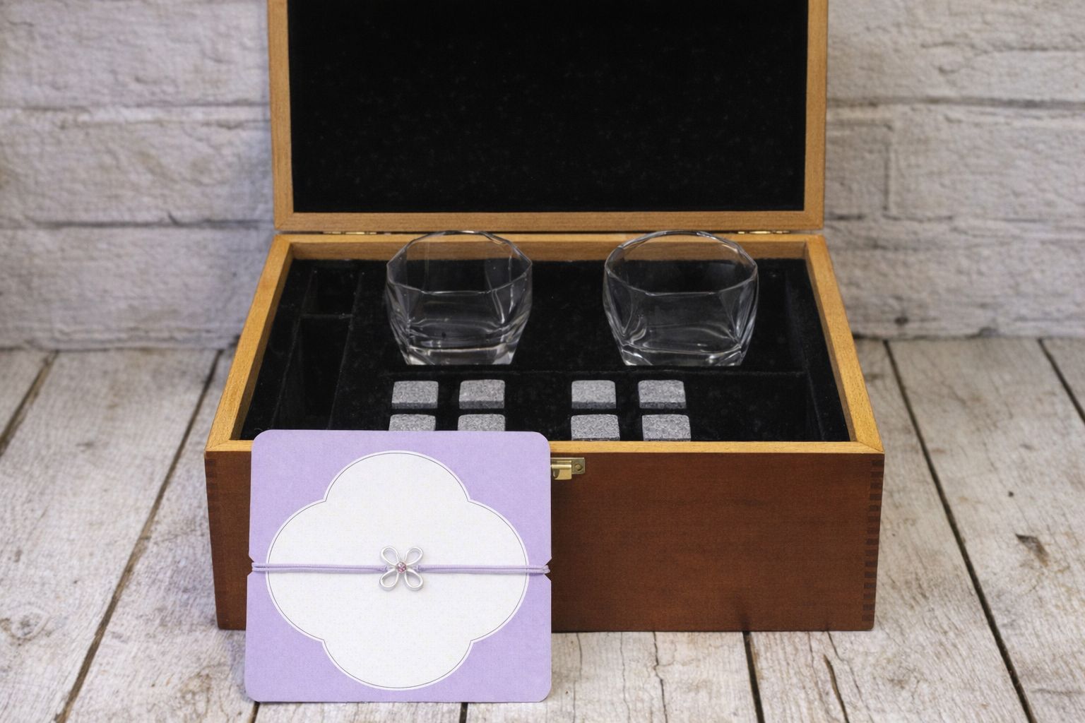 Presentförpackning med kristallglas, täljstenar och ett dekorativt kort.